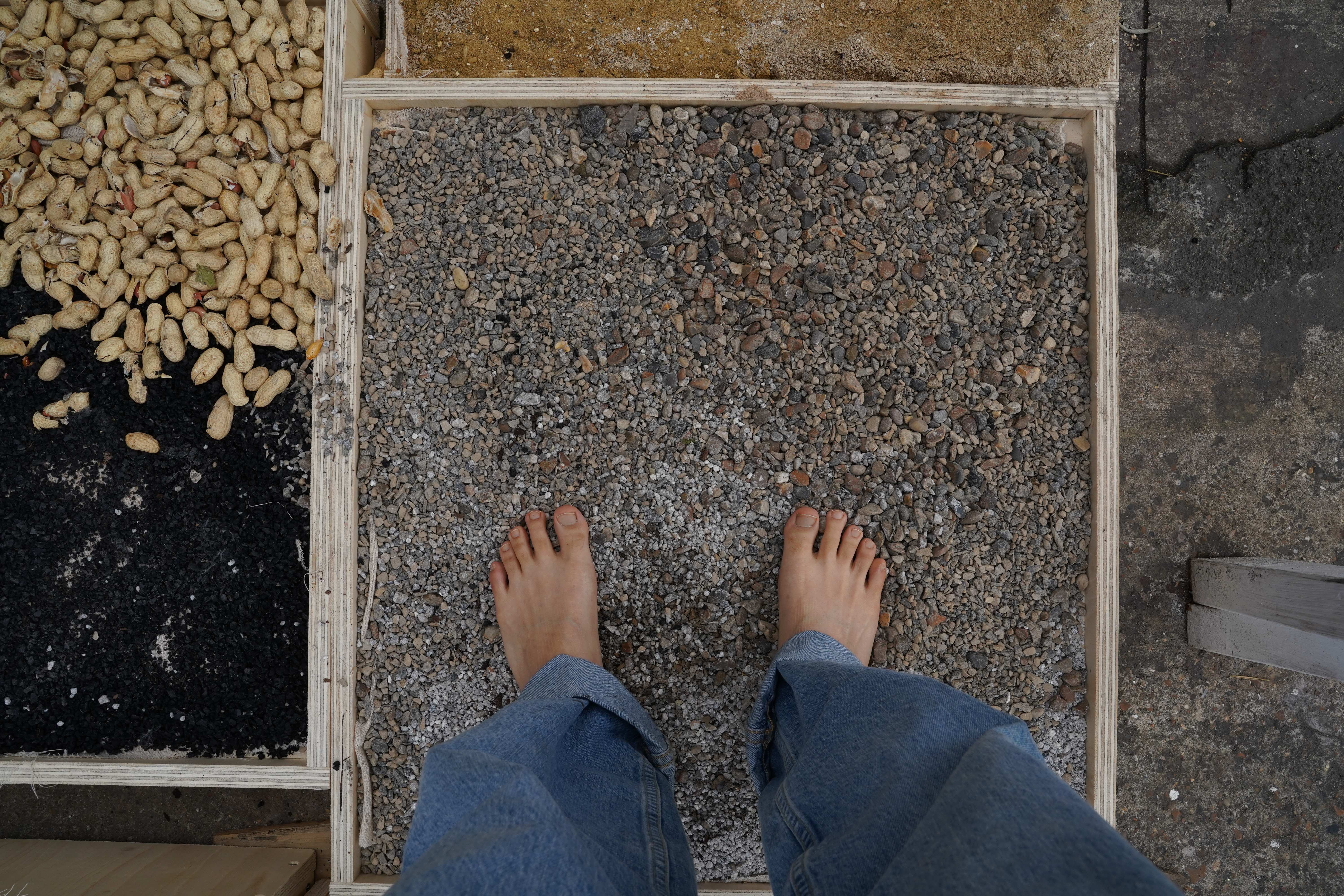 Bare feet standing on gravel pebbles